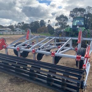 Yeomans plow with fixed shanks, hydraulic wheels and crumble roller