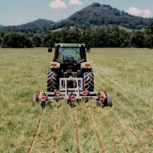 Yeomans plow L4310 5 26 5 18 coulters depth control using a john deere in a green grassy field